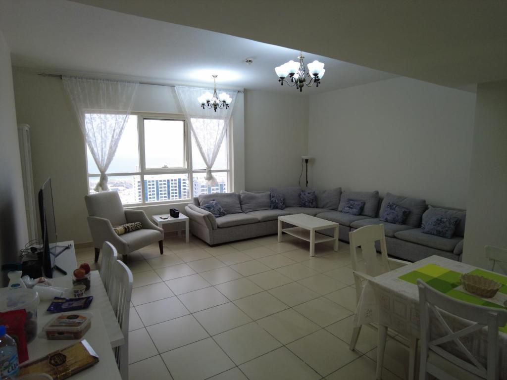 a living room with a couch and a table at إمارة الشارقة منطقة الخان شقة مفروشة غرفتين و صالة أجار 15 يوم أو شهر in Al Khān