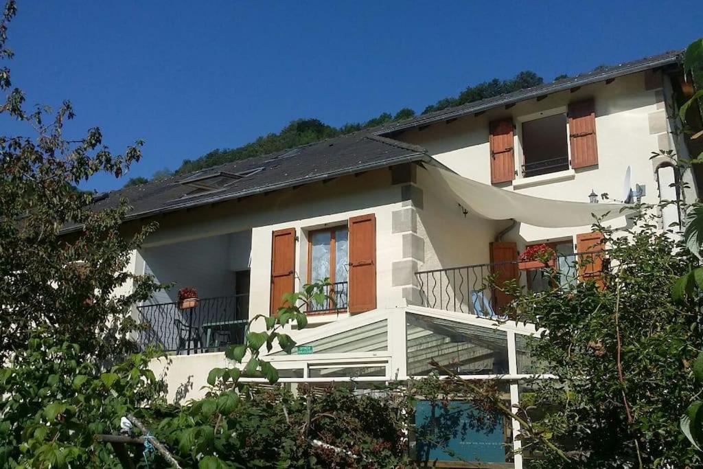 Casa blanca con porche y balcón en Gite en duplex 4 personnes, Vallée de la Jordanne, Cantal, en Lascelle