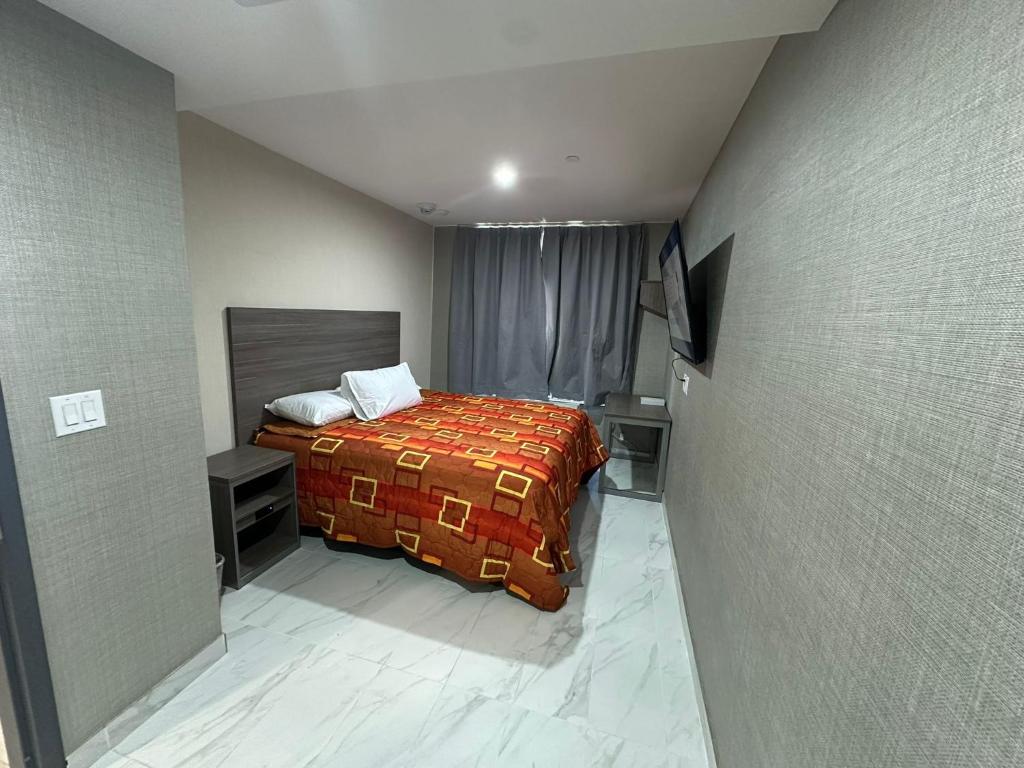 Kleines Zimmer mit einem Bett und einem TV in der Unterkunft Hotel Fuego Bronx in Bronx