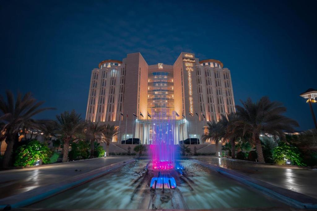 - un grand bâtiment avec une fontaine devant lui la nuit dans l'établissement Khawarnaq Palace Hotel, à An Najaf