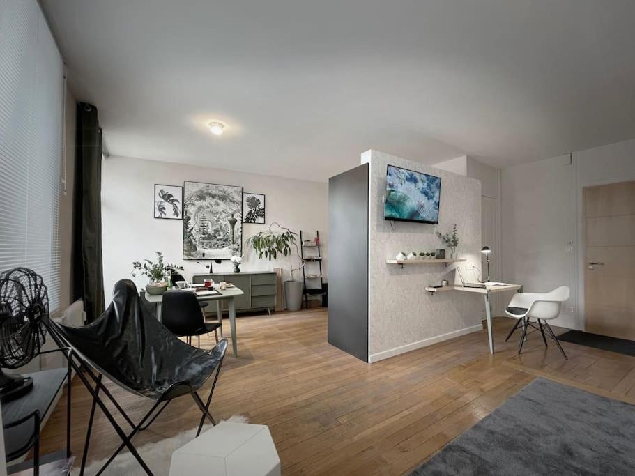 ein Wohnzimmer mit Stühlen und Tischen in einem Zimmer in der Unterkunft Grand studio confortable situé en centre ville in Gérardmer