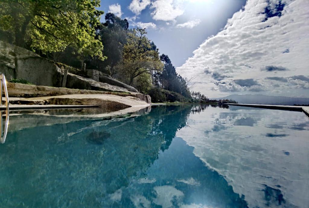 une masse d'eau avec des arbres et des nuages dans le ciel dans l'établissement Quinta do Penedo Real, à Viana do Castelo