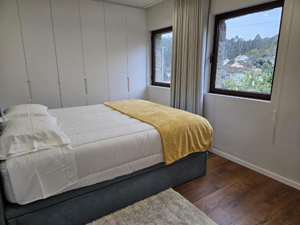 um quarto com uma cama com um cobertor amarelo em Quinta do Penedo Real em Viana do Castelo