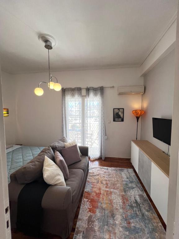 een woonkamer met een bank en een bed bij Διαμέρισμα με βεράντα δίπλα στα ΜΜΜ in Athene