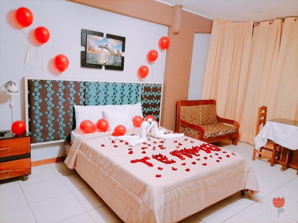 Un dormitorio con una cama con globos rojos. en Confort pichanaki, en Pichanaki