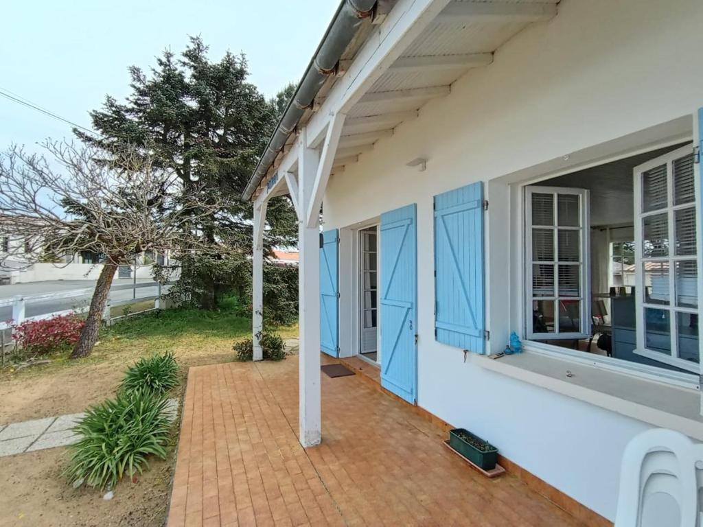 une terrasse couverte d'une maison avec portes bleues dans l'établissement Soledam, à La Tranche-sur-Mer