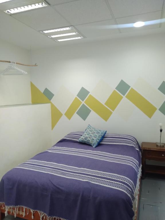 a bedroom with a bed with a geometric wall at Céntrica y confortable habitación in Oaxaca City