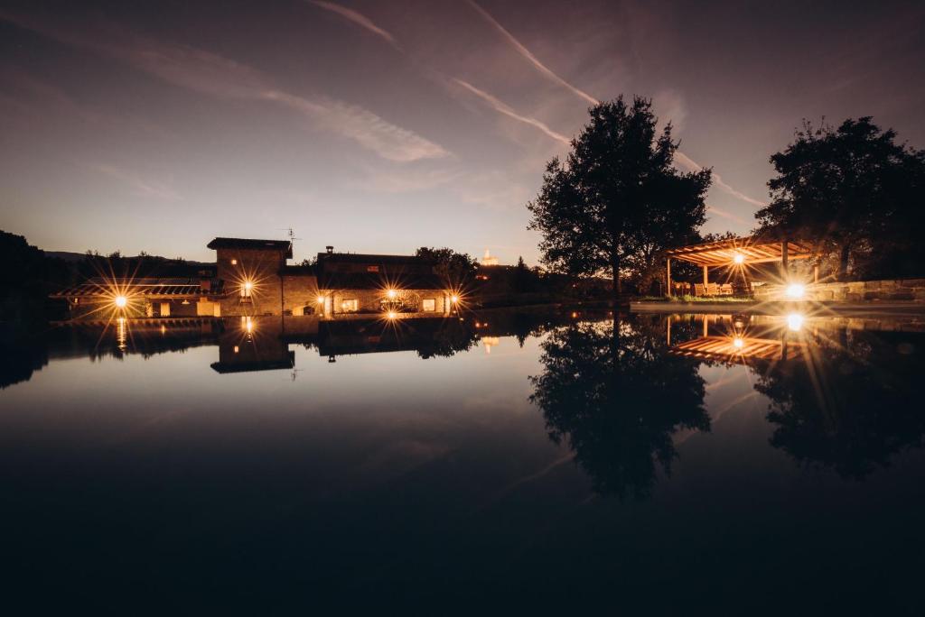 a building with lights on the water at night at Agriturismo La Dolce Vista in Poppi