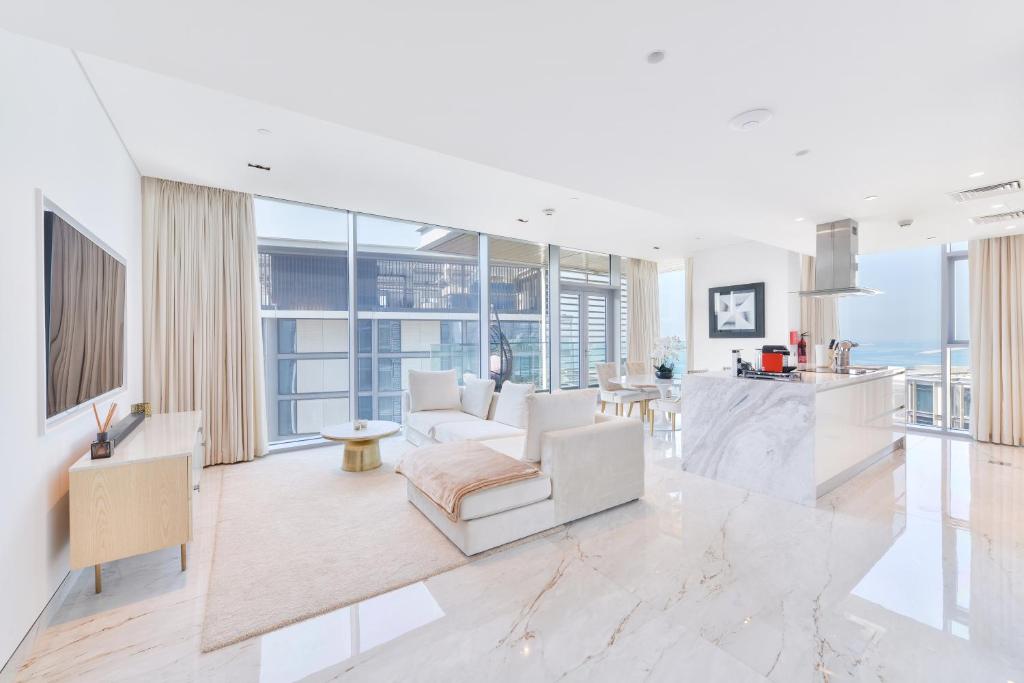 ドバイにあるPremium 2+1 BR condo in the heart of Bluewaters Islandの白いリビングルーム(ソファ付)、キッチンが備わります。