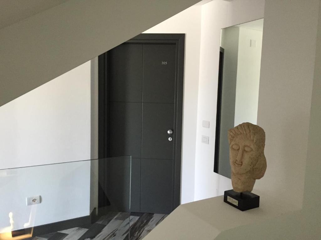 a statue sitting on a table next to a black door at Residenza RoMa in Tropea