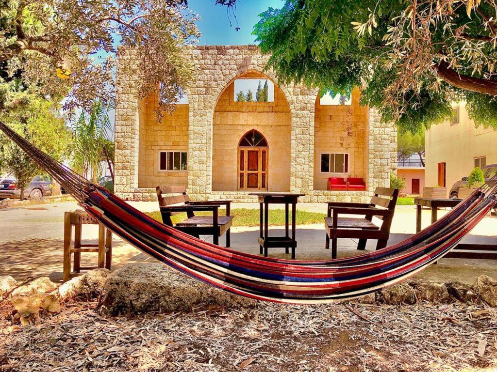 a hammock sitting in front of a building at The Ranch in Kfar Hazîr