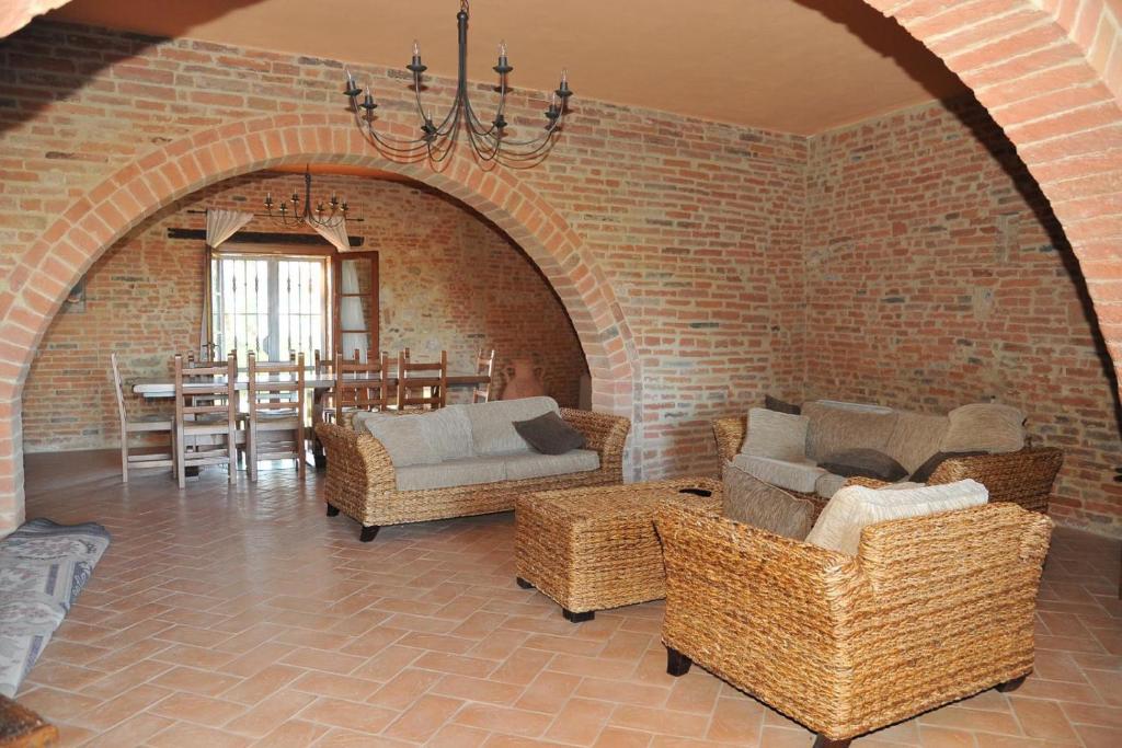 sala de estar con sillas de mimbre y pared de ladrillo en Il Granaio, en Strada