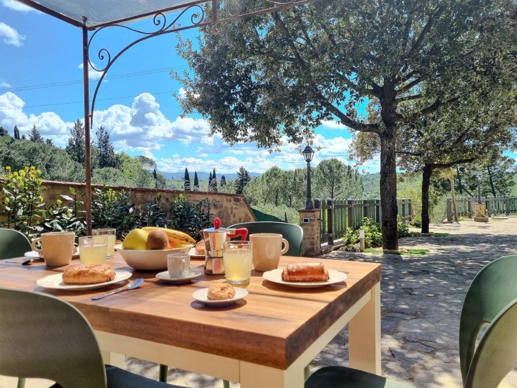 a wooden table with food on top of a patio at Casa Iris - Home In the heart of Tuscany & jacuzzi in Bibbiano