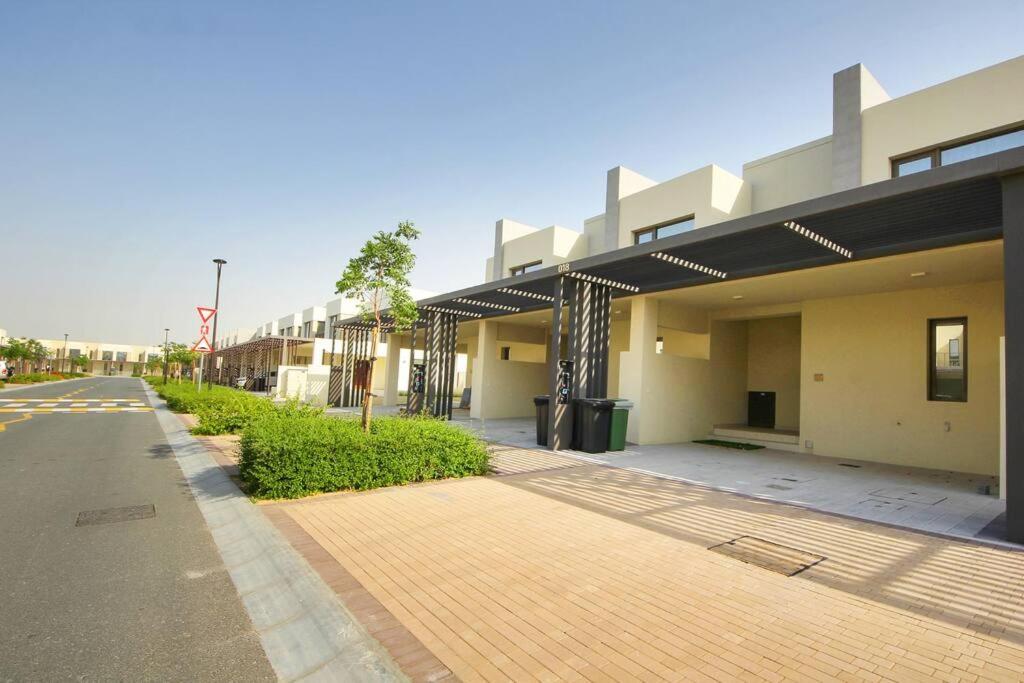 an empty street in front of a building at Green Haven 3BR Villa-Golfside Grandeur-Emmar South in Dubai