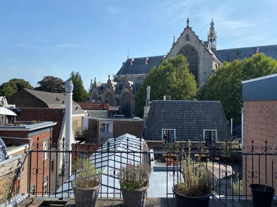 a balcony with potted plants in front of a church at Apartment City Center Terrace with Iconic View in Gouda
