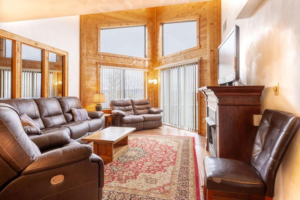 un soggiorno con divano in pelle e TV di Four-Bedroom Apartment a Champion