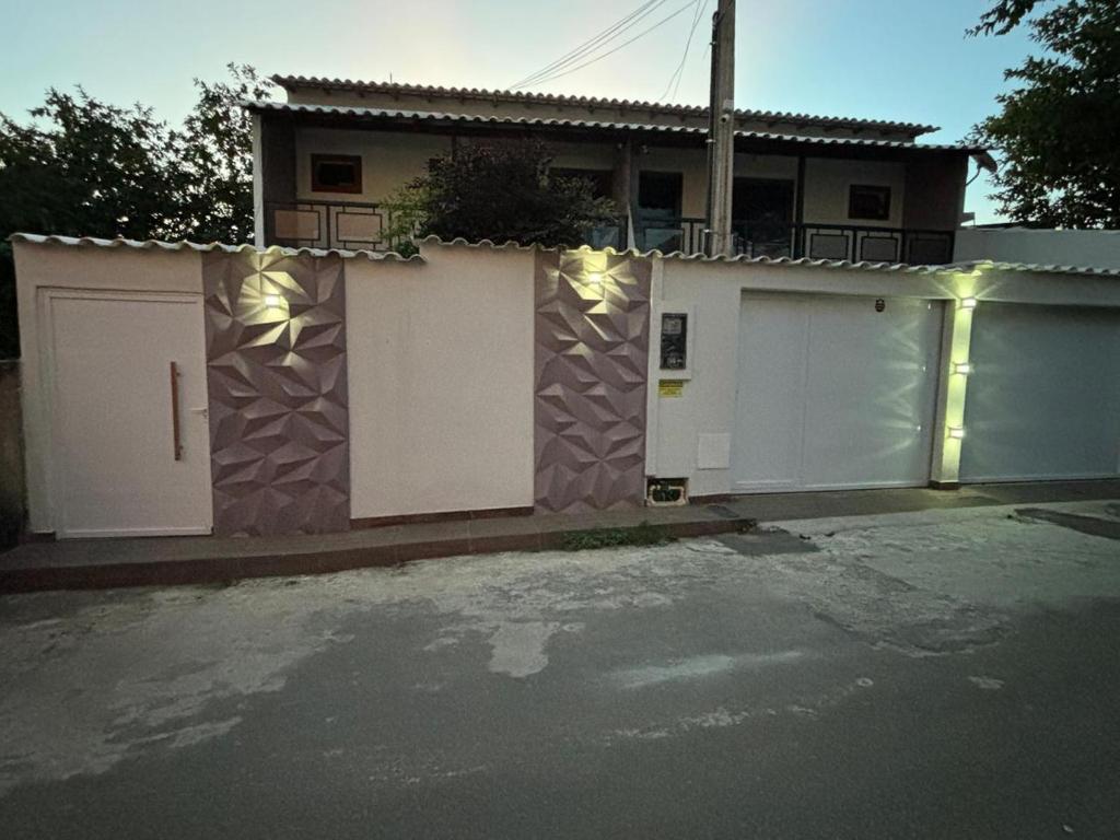 una casa con puertas blancas y una valla en Casa Iriri, en Anchieta