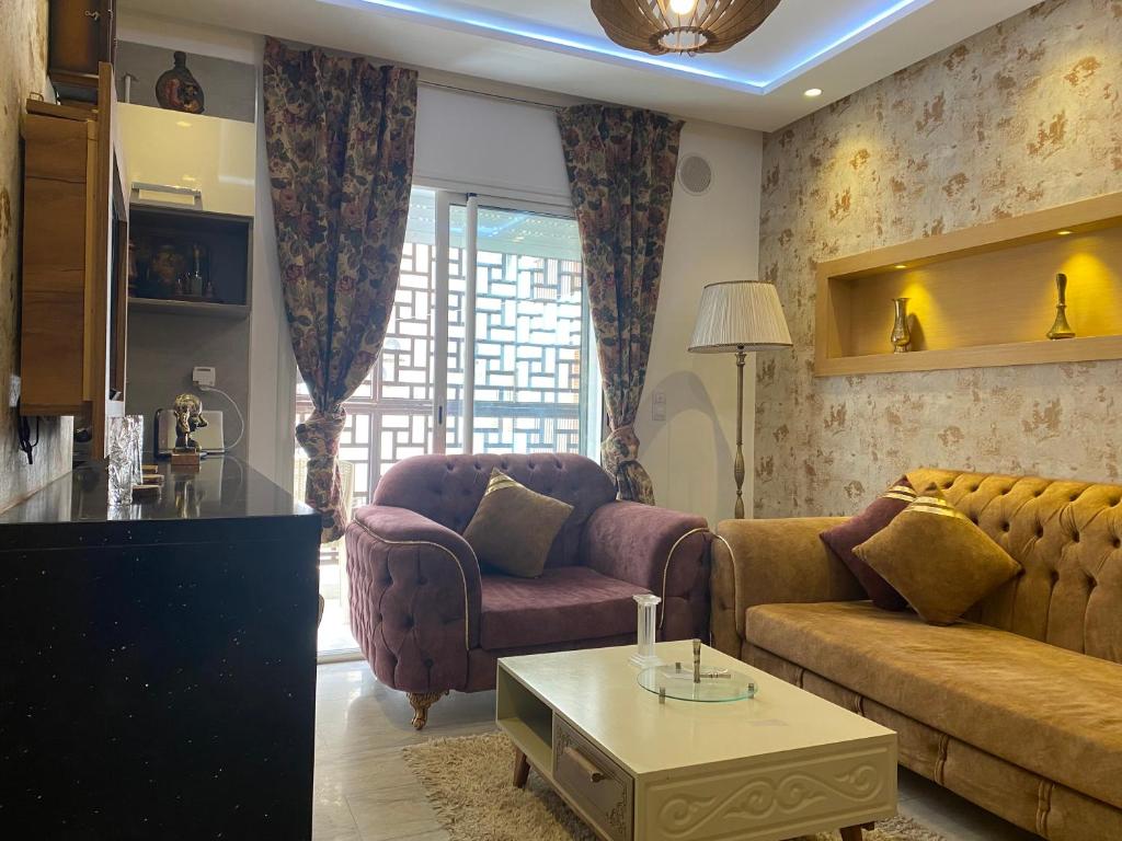- un salon avec un canapé et une table dans l'établissement Coquette appartement sahloul 4, à Sousse