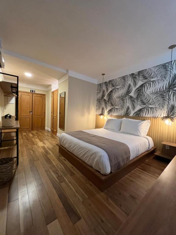 um quarto com uma cama grande e um mural na parede em JaguatiricaCoffee Hospitality em Monte Verde