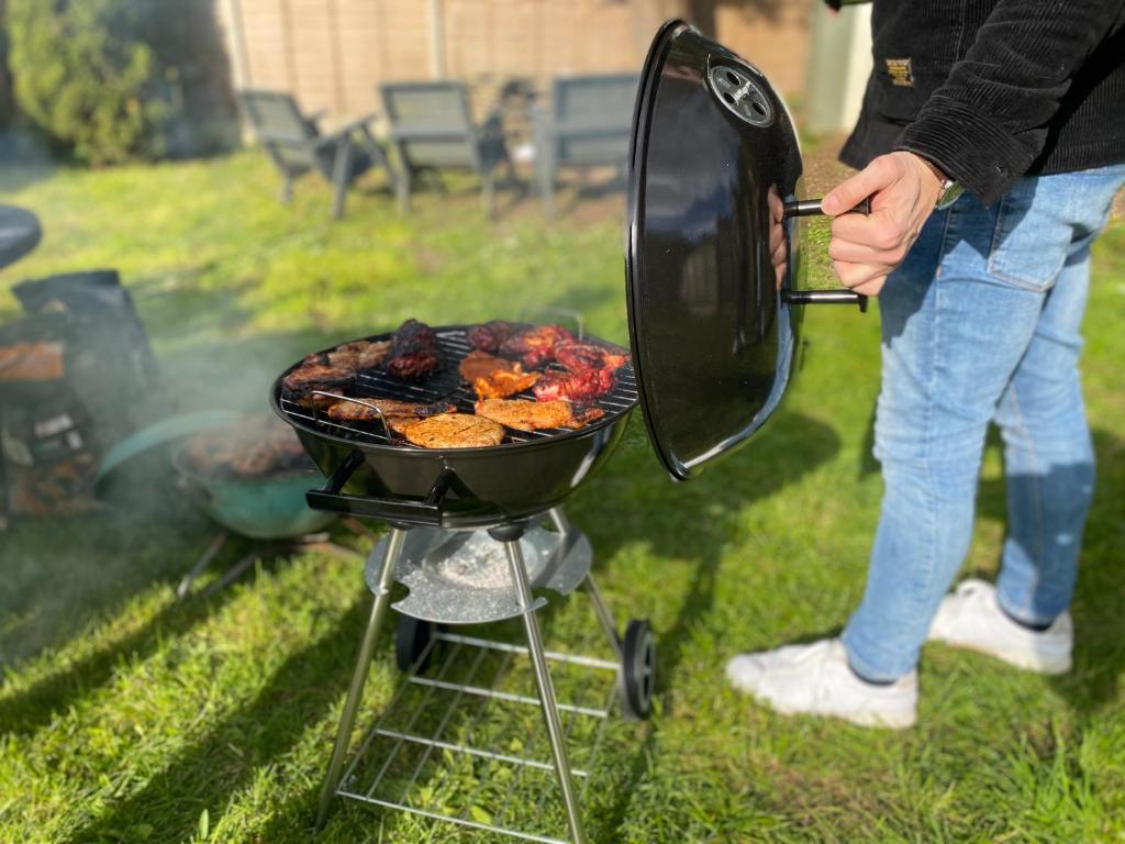 a person is cooking food on a grill at 3 Bedrooms house ideal for long Stays! in Southampton