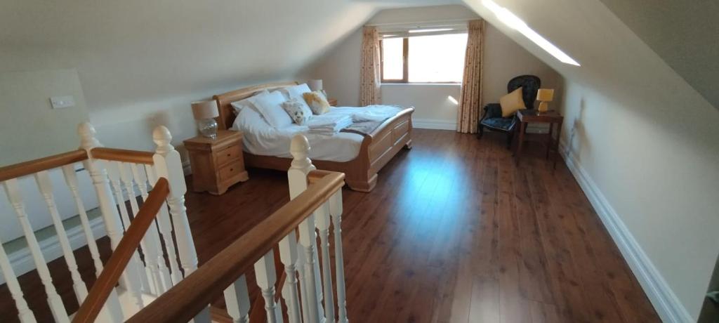 een slaapkamer met een bed en een trap met een raam bij Mortara Cottage in Ballylongford