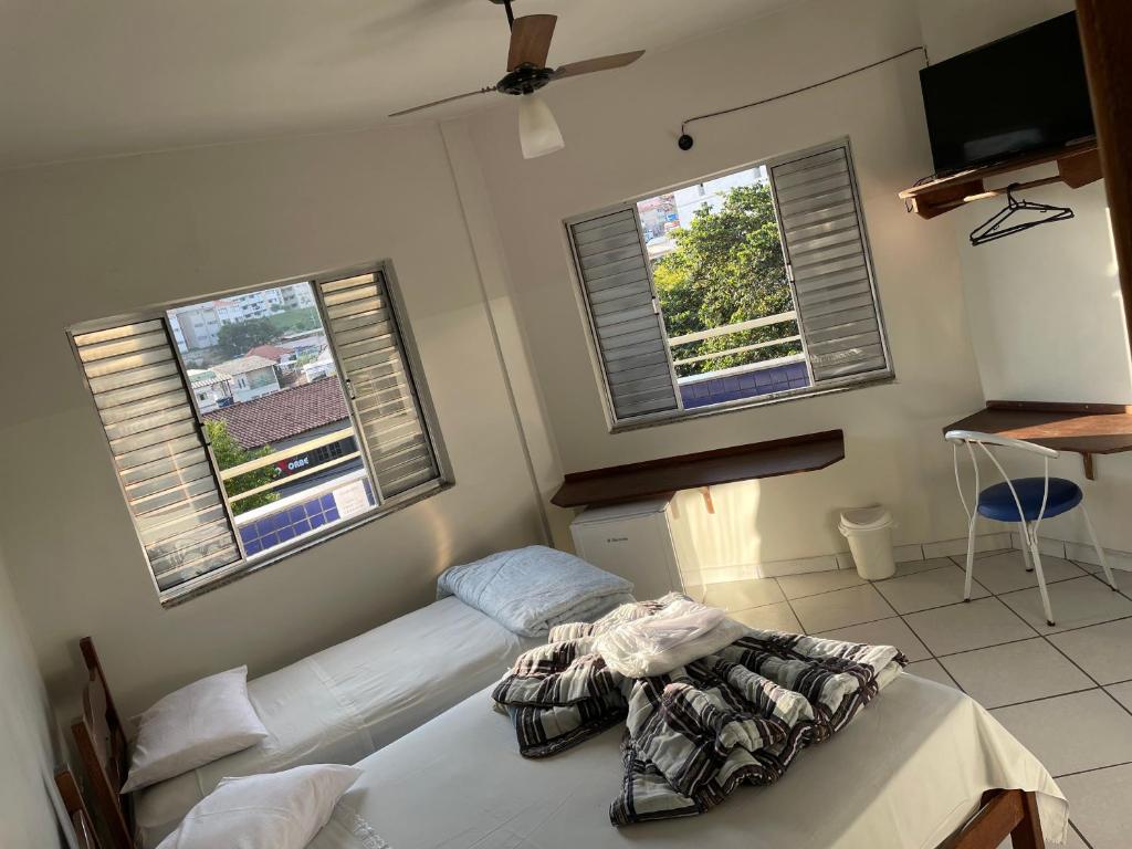 um quarto com 2 camas e 2 janelas em Hotel Calcinfer em São João del Rei
