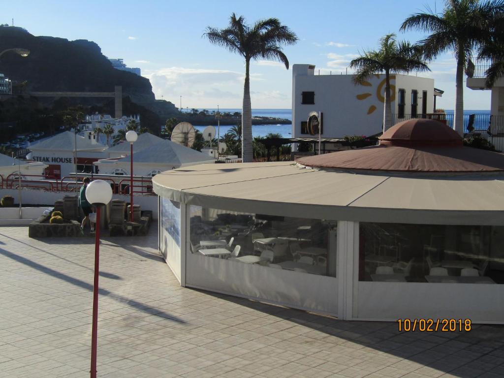 un edificio con un ristorante su una strada con palme di El Cardenal a Playa del Cura