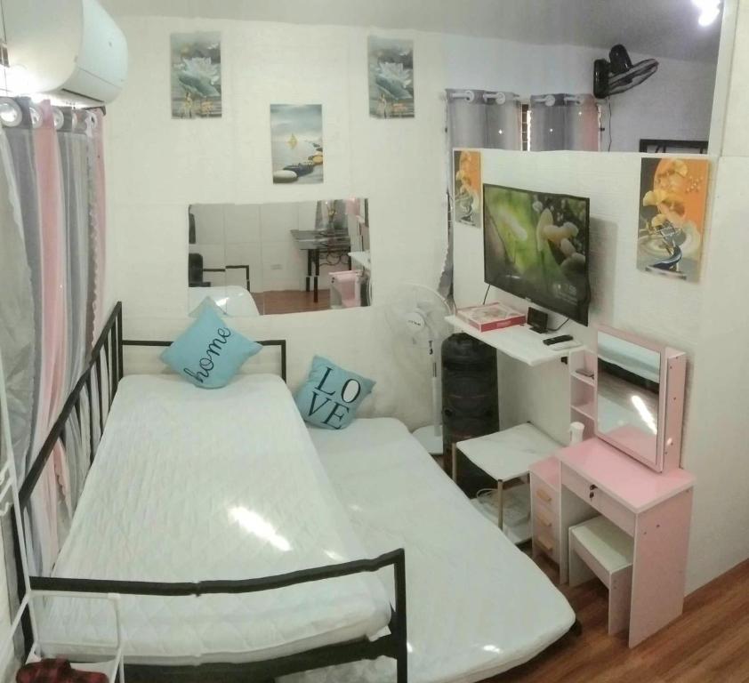 Habitación pequeña con cama y escritorio. en Homey Inn-Olango Island Staycation ,block 1 lot 15, en Lapu Lapu City