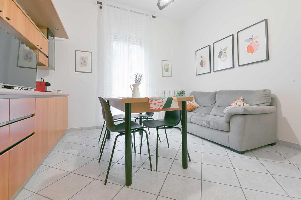 a kitchen and living room with a table and a couch at QUEEN HOME Bianca in Bologna