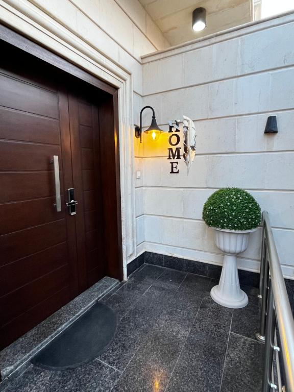 uma porta para uma casa com uma planta ao lado em شقة مريحة فاخرة Cozy apartment, luxury with fun em Jidá