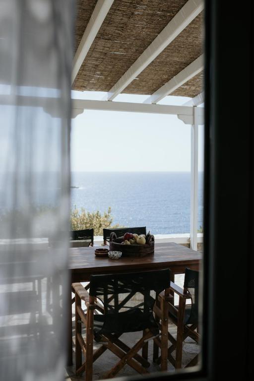 a table with a bowl of fruit sitting on top of the ocean at The Sunset by KHI in Kithnos