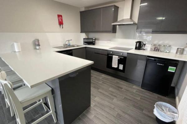 a kitchen with a white counter and black cabinets at RYAN I AIR I BNB - 102 Mill Street - Free Parking in Liverpool