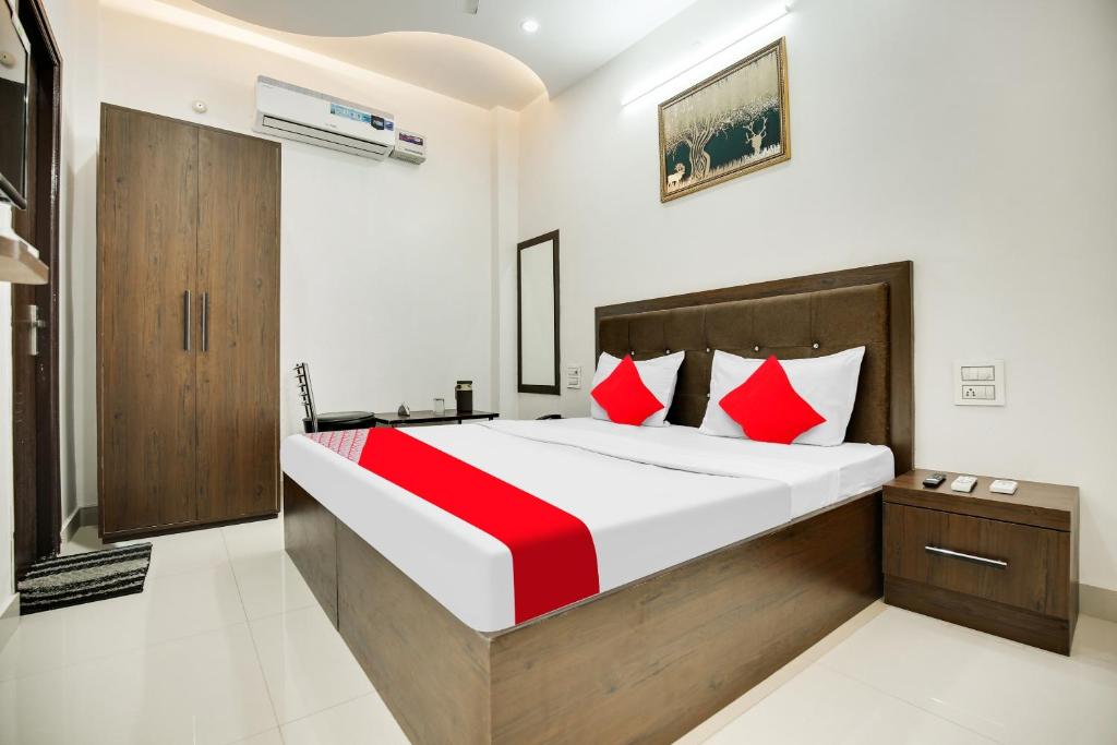 sypialnia z dużym łóżkiem z czerwonymi poduszkami w obiekcie Super OYO Flagship King Star Residency w mieście Bathinda