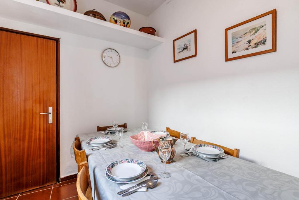 a dining room table with a blue table cloth and a clock at Casa Delgado in Tavira