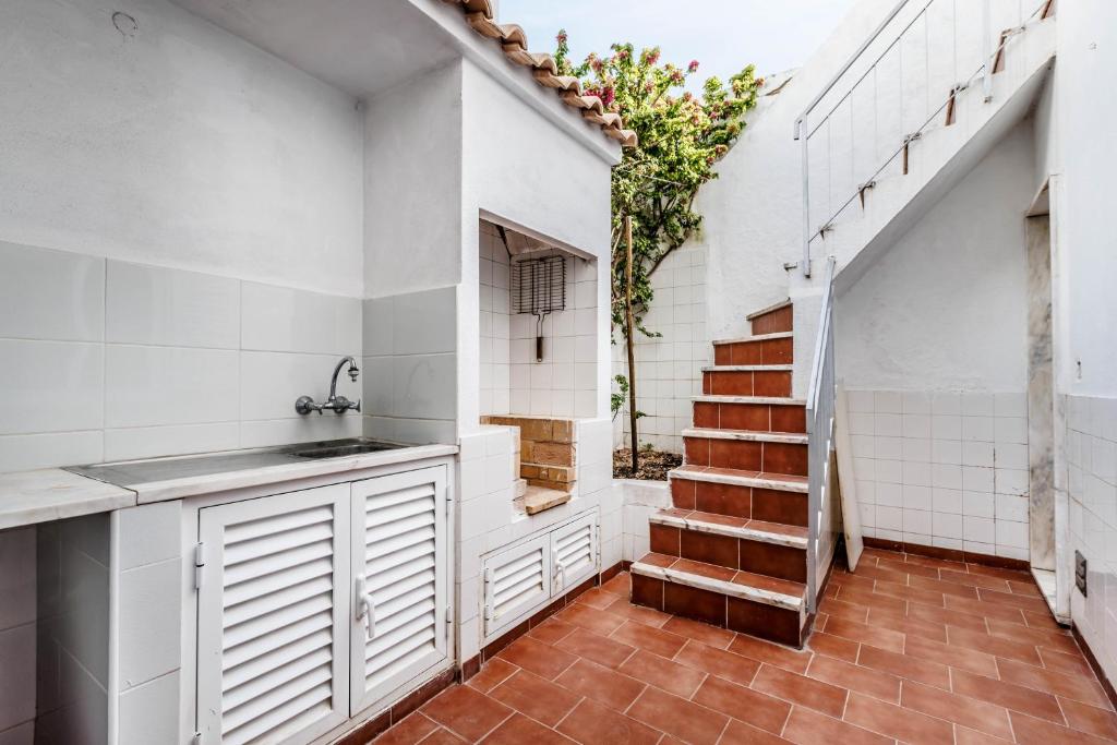 a kitchen with a sink and a stairway at Casa Delgado in Tavira