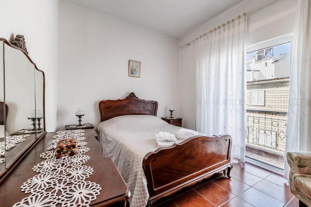 a bedroom with a bed and a large window at Casa Delgado in Tavira