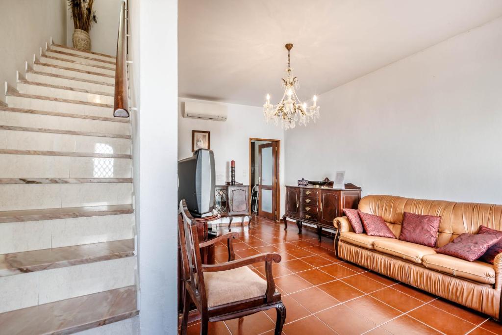a living room with a couch and a tv at Casa Delgado in Tavira