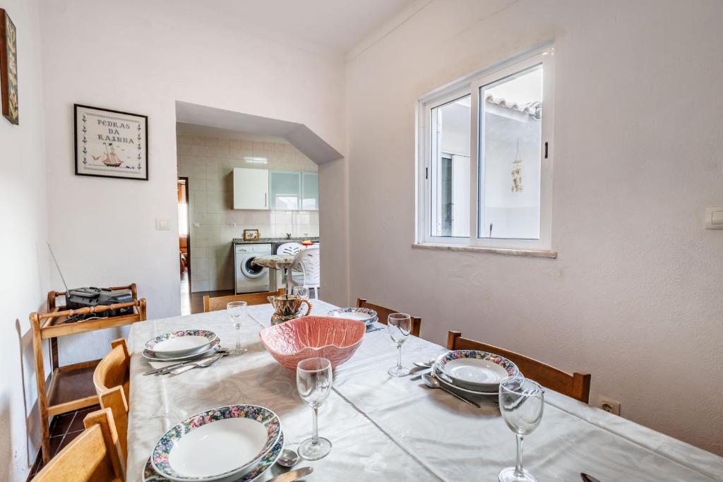 a dining room table with plates and wine glasses at Casa Delgado in Tavira