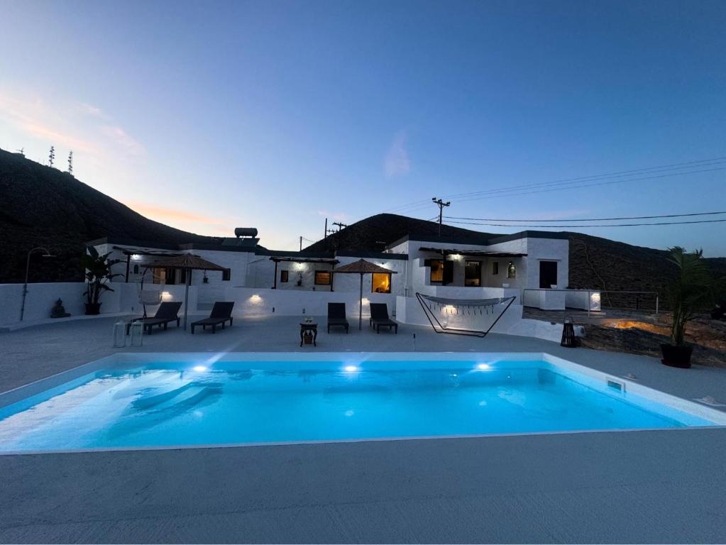 a swimming pool in front of a house at O Mylos in Ermoupoli