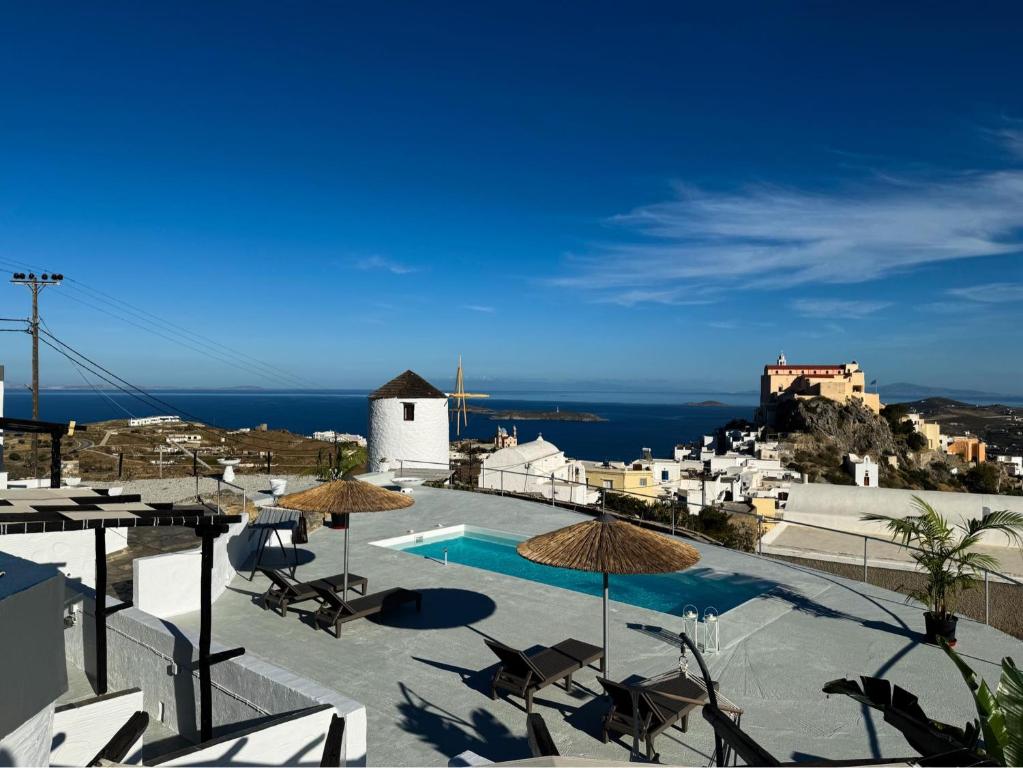 a view of a pool with chairs and umbrellas at O Mylos in Ermoupoli