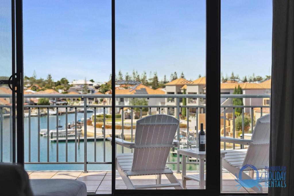 duas cadeiras numa varanda com vista para uma marina em Tuscan Escape in Wannanup em Wannanup