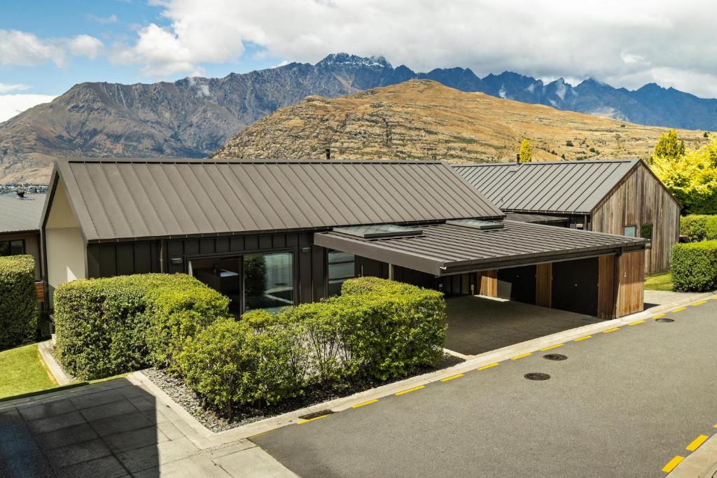 a house with a roof with mountains in the background at Home Away from Home in Queenstown