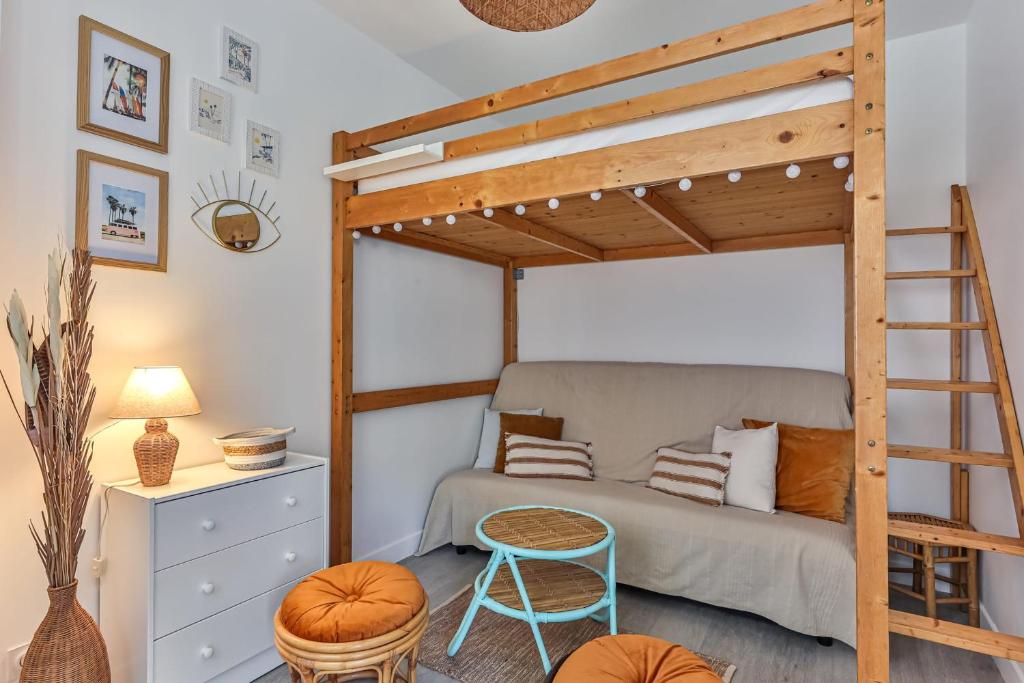 ein Schlafzimmer mit einem Etagenbett mit einer Leiter in der Unterkunft LE SPOT -T2 à 100m de la grande plage in Saint-Gilles-Croix-de-Vie