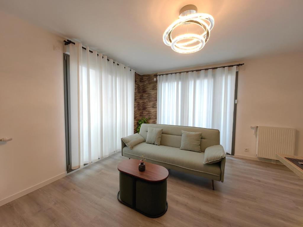 ein Wohnzimmer mit einem Sofa und einem Tisch in der Unterkunft sacha&#39;s house ,à coté du RER,val d&#39;europe,Paris-Disney . in Bussy-Saint-Georges