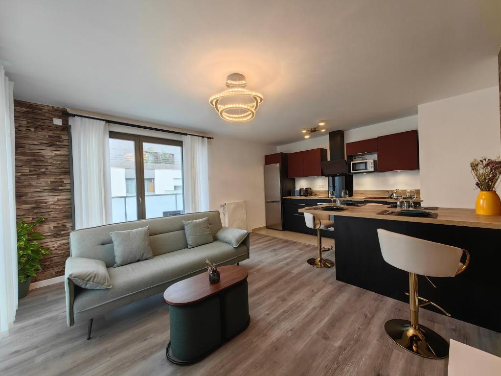 ein Wohnzimmer mit einem Sofa und einer Küche in der Unterkunft sacha&#39;s house ,à coté du RER,val d&#39;europe,Paris-Disney . in Bussy-Saint-Georges