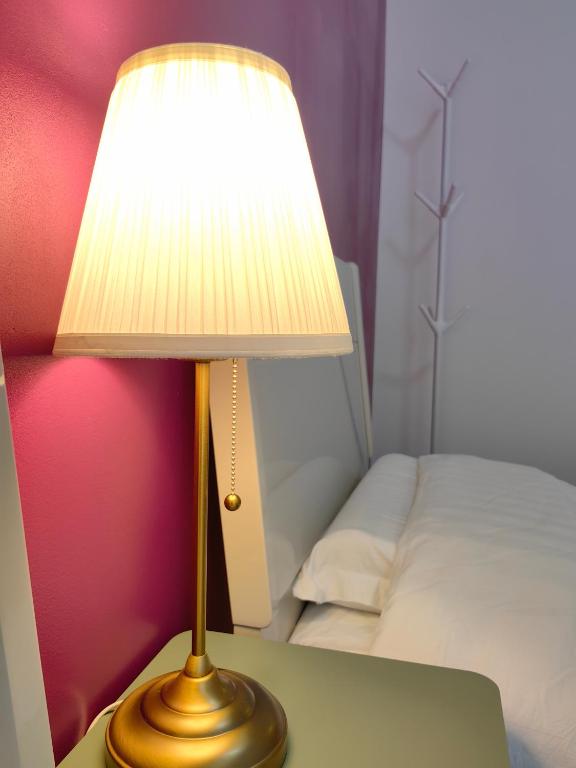 eine Lampe auf einem Tisch neben einem Bett in der Unterkunft sacha&#39;s house ,à coté du RER,val d&#39;europe,Paris-Disney . in Bussy-Saint-Georges