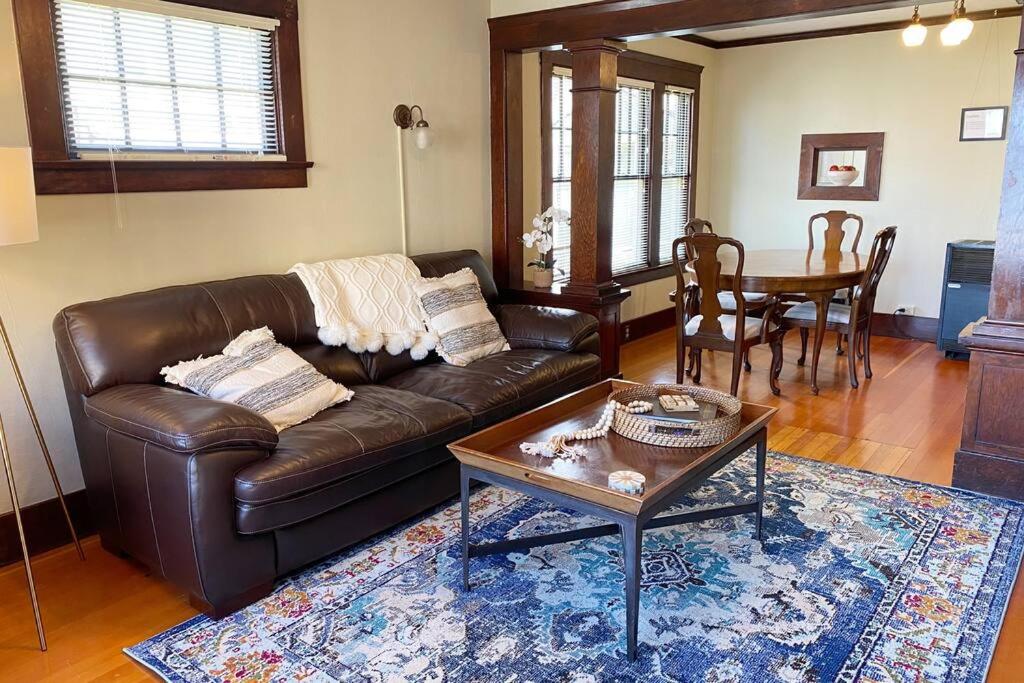 uma sala de estar com um sofá de couro e uma mesa em Historic Downtown Riverview Flat, No. 2 em Astoria