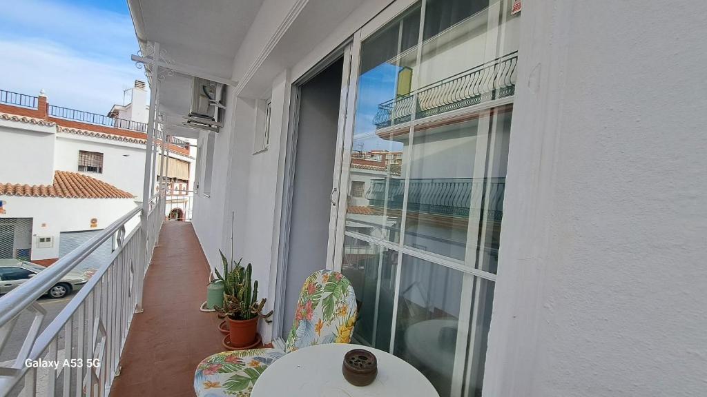 a balcony with a table and chairs and a window at Carmen Guest House in Benalmádena
