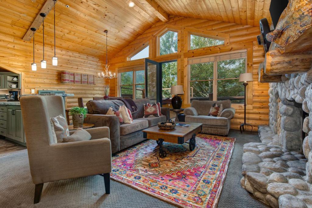 a living room with couches and a stone wall at Luxury Condo Near Year-Round Recreation, Free Shuttle & Hot Tub! Deer Valley Comstock Lodge 302 in Park City