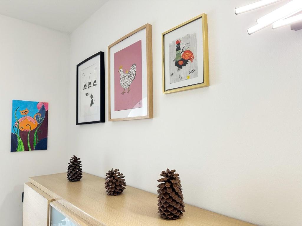 a room with four pictures on a wall with a table at Relaxing Ocean View, Spacious Art Apartment With Large Terrace, Near Best Costa Adeje Beaches in Adeje